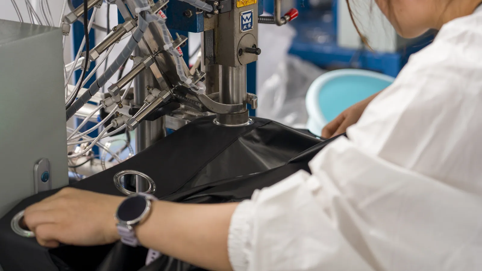 Grommets being pressed into a blackout curtain panel at Xinlan