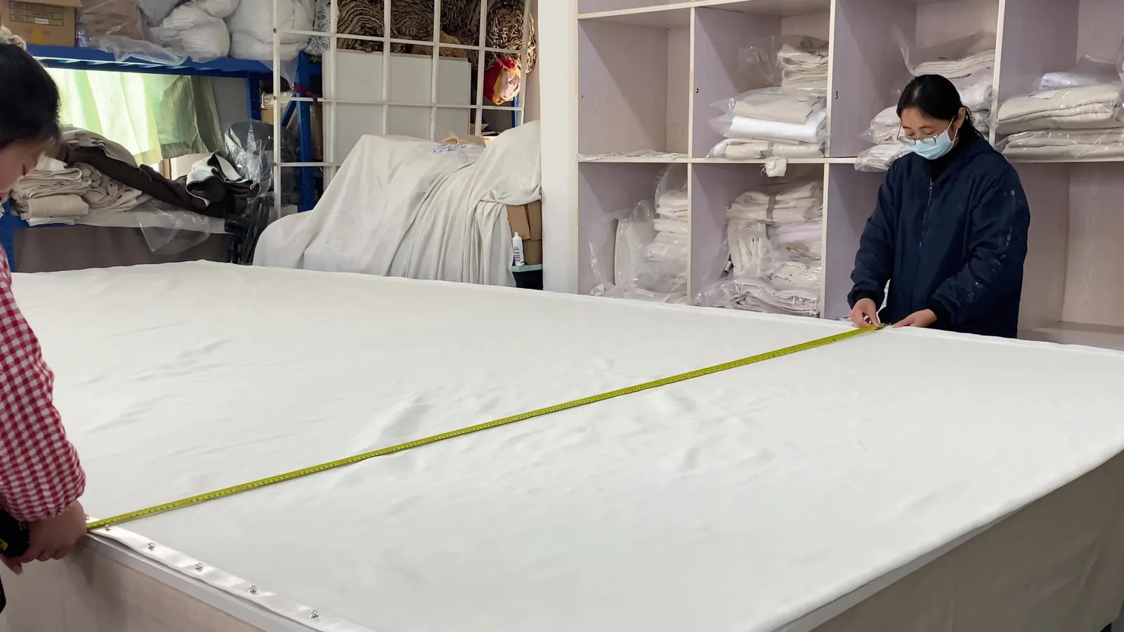 Xinlan staff measuring fabric on the inspection table