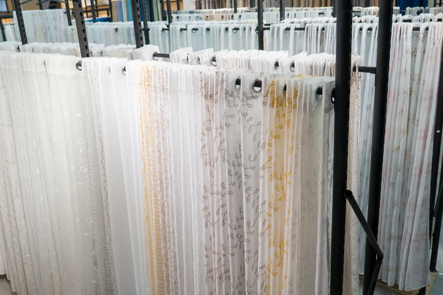 Sheer and voile curtain samples on display racks in the Xinlan showroom
