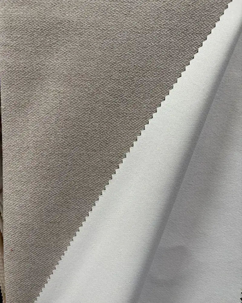 Blackout curtain fabric showing the woven face and the coated back